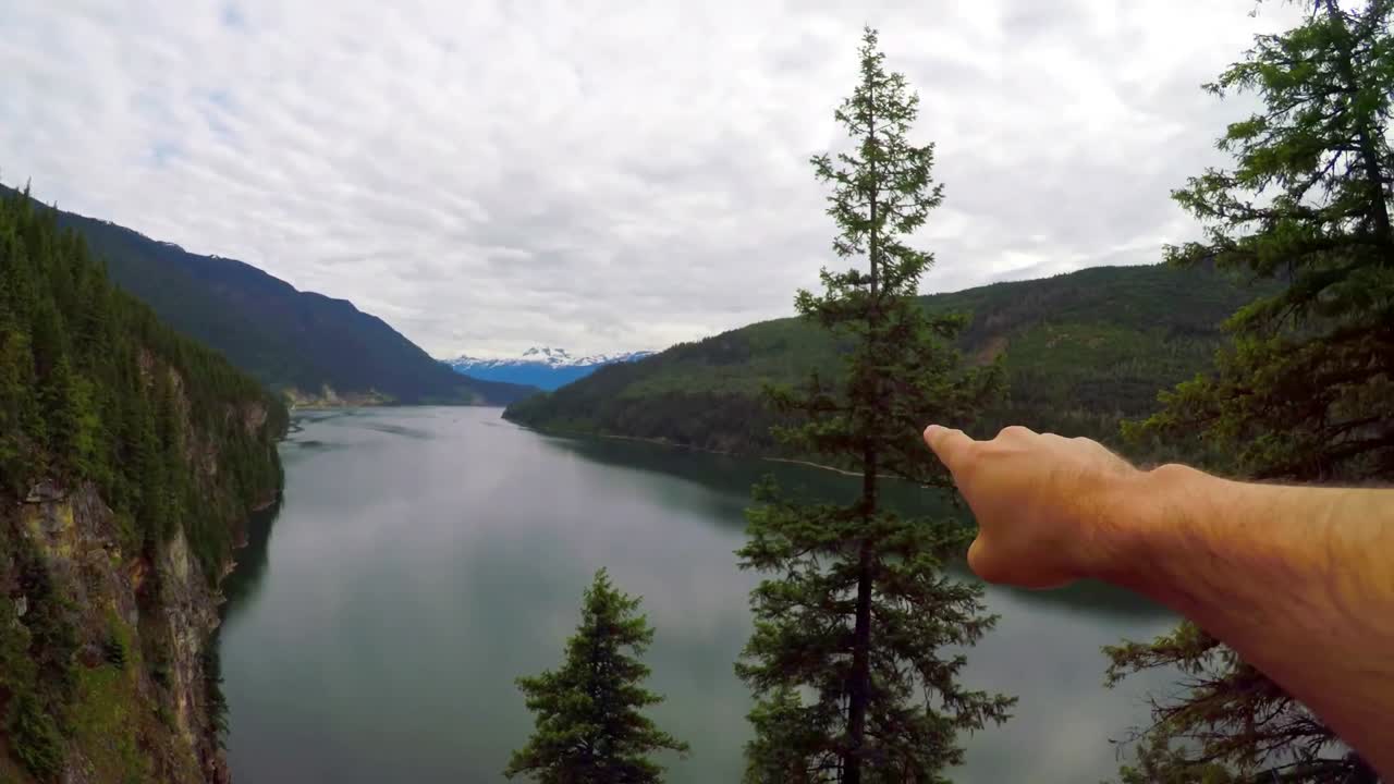 Escursionista che indica in lontananza 4k