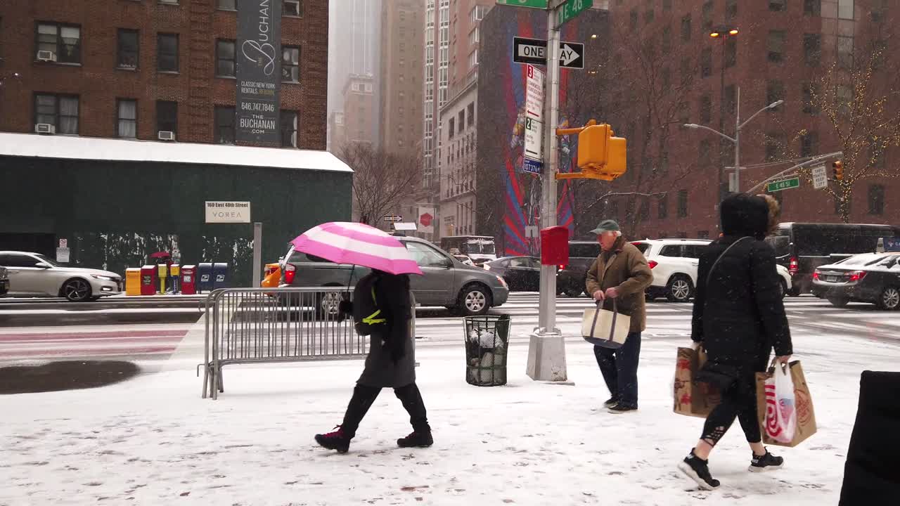 Cinematic and slow motion shots filmed in New York City during a snowstorm. DYNAMIC pedestrians and vehicles. Forward reveal.