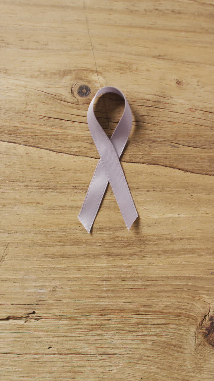 вертикальное видео розовой ленты на деревянном фоне