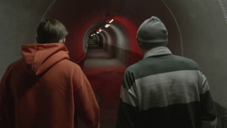 friends walking through dark tunnel