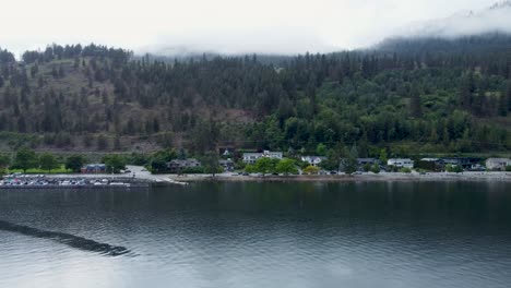 drone flying across the lake towards the shoreline