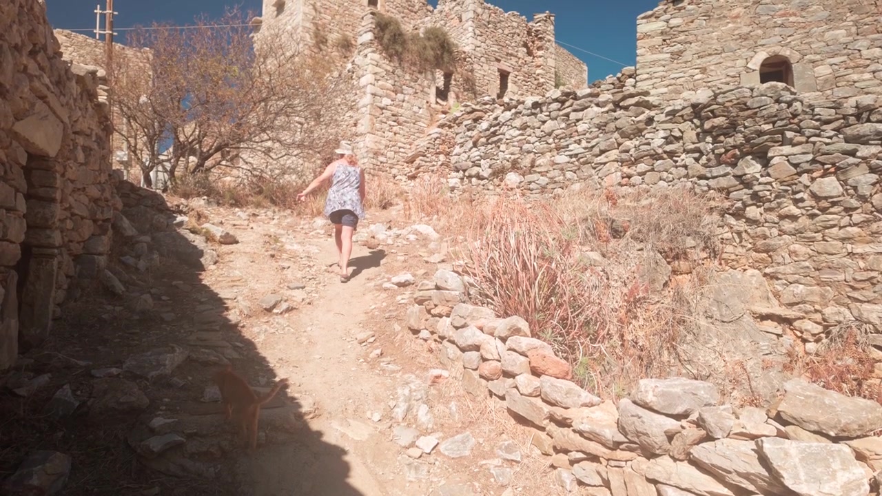 Donna cammina tra le rovine in pietra del villaggio abbandonato di Vathia nel Mani.