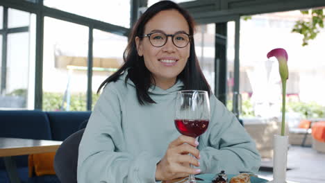 woman enjoying wine and dessert in a cafe
