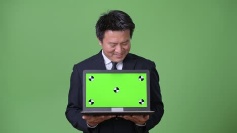 녹색 배경에 성숙한 일본 사업가