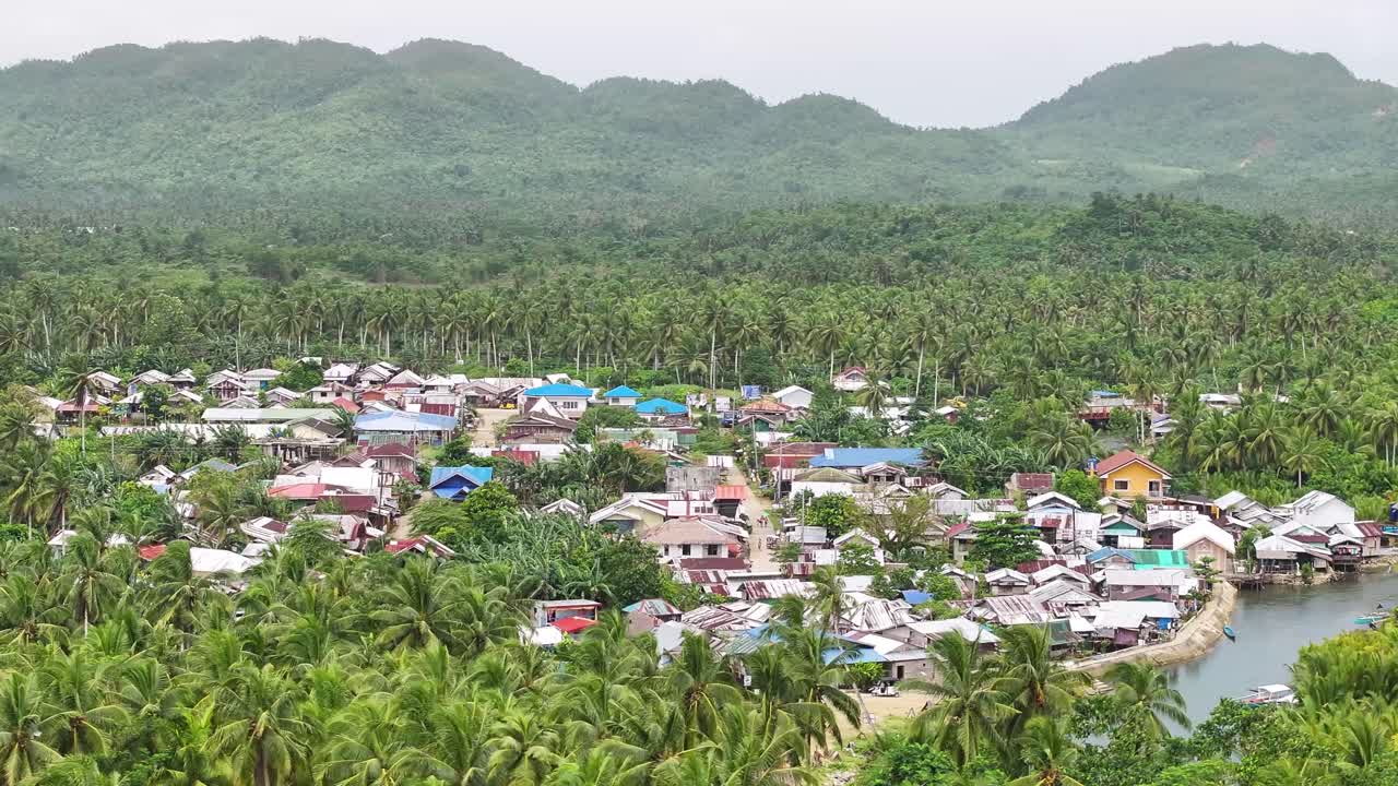 Filipino village by the river surrounded by palm trees, province in Siargao Island, Philippines.