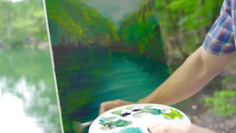 male artist painting outdoors.