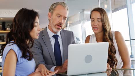 Businessman-and-colleague-interacting-using-laptop