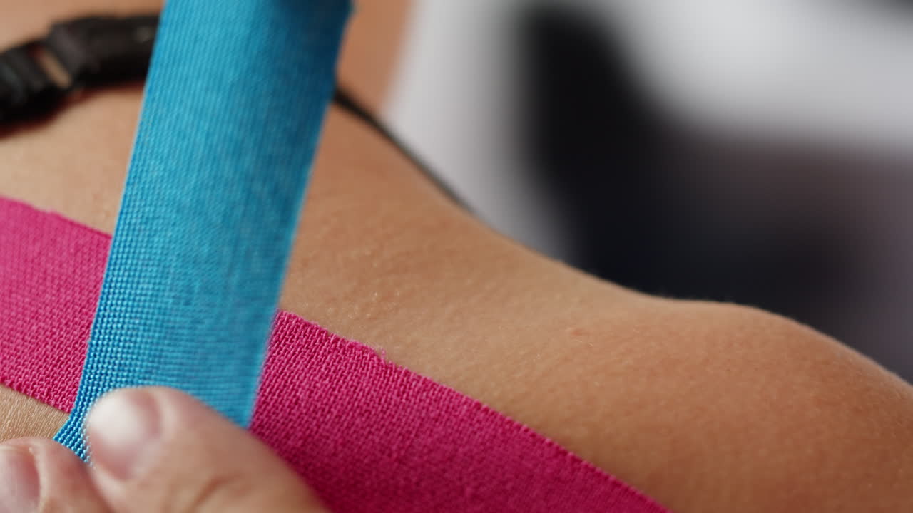Kinesiology medical taping, doctor Physical therapist applying elastic surgical tape to patient body, treating injured knee young athlete.Post traumatic rehabilitation, sport physical therapy recovery