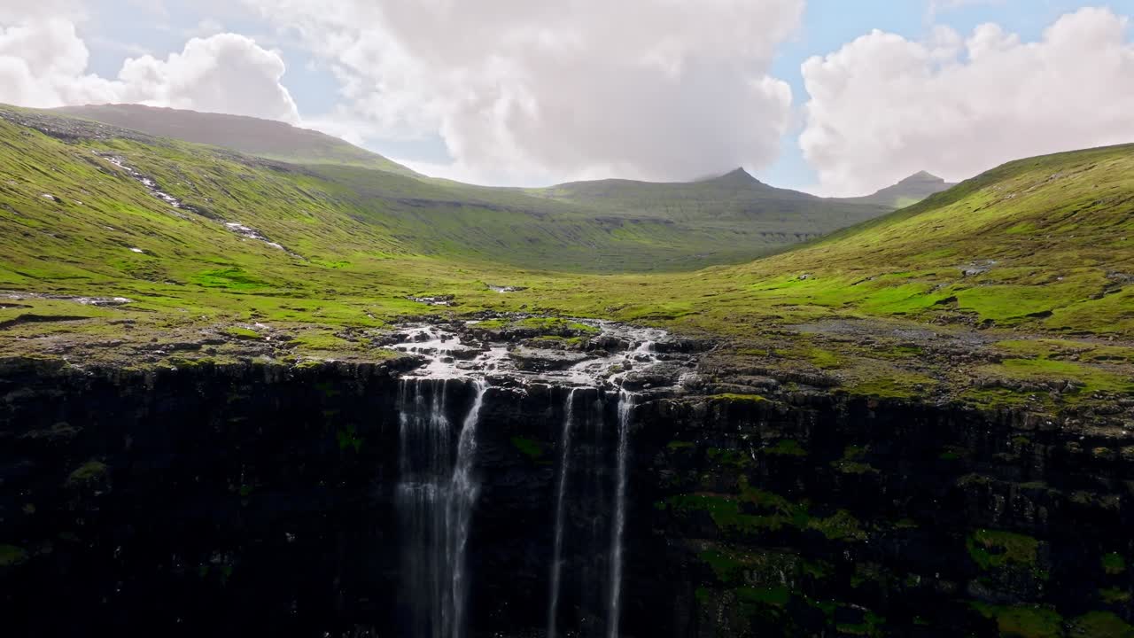 un sereno valle verde con cascadas en cascada bajo un cielo brillante, las islas feroe