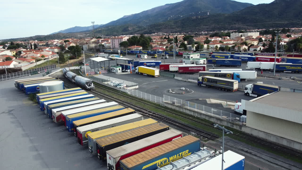 Aerial view of a busy trucking terminal with parked trailers and rail line