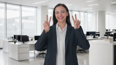 mujer gerente india feliz mostrando el signo de la victoria