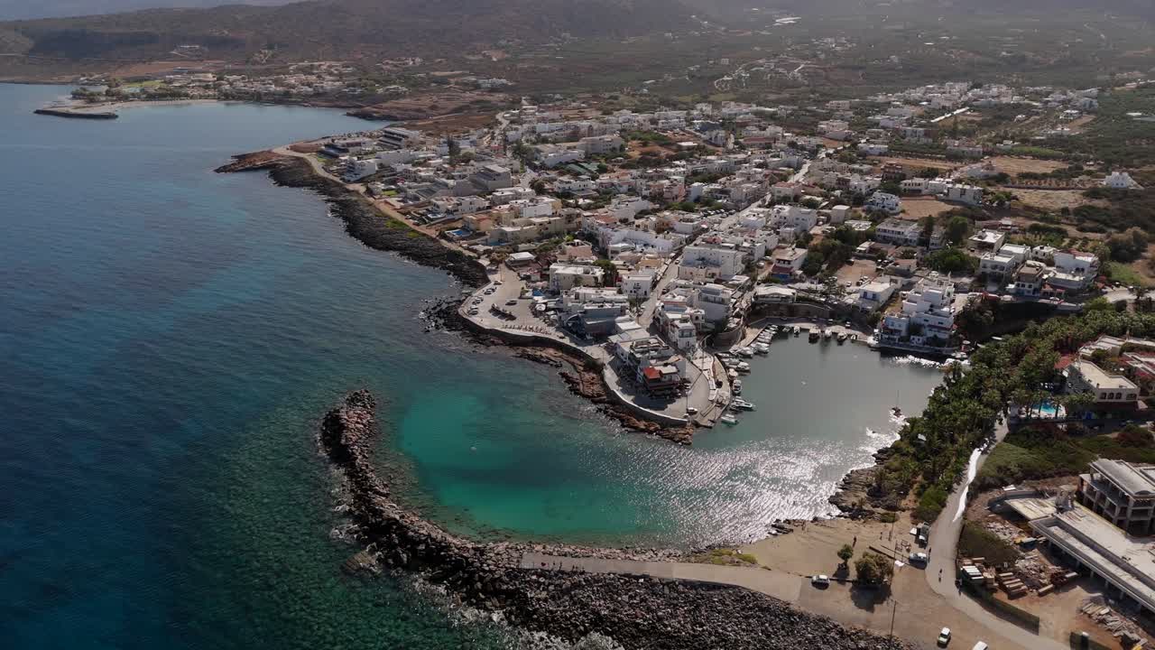 Aerial - scenic Sissi Bay with vibrant village and turquoise waters in Crete Greece