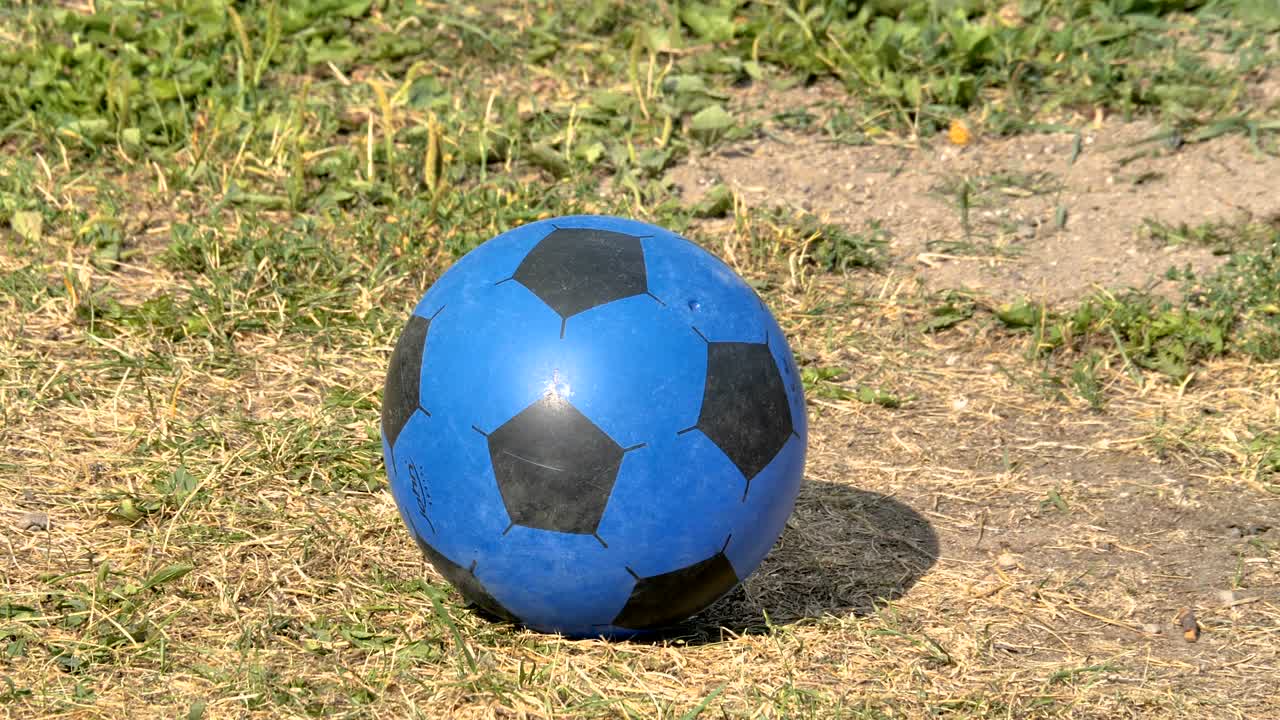 una pelota de fútbol azul y negra en el suelo