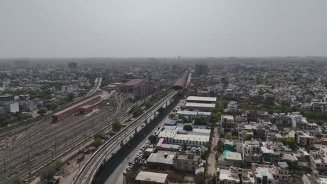 overhead perspective of jaipur's dense cityscape with railway tracks and metro train station