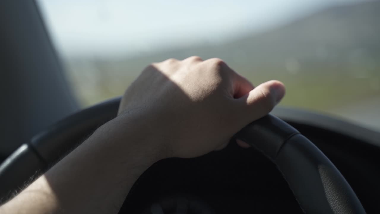 This is a clip of a hand on a car wheel driving. Cinematic, I think so.