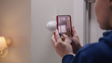 woman monitoring home security camera through smartphone app