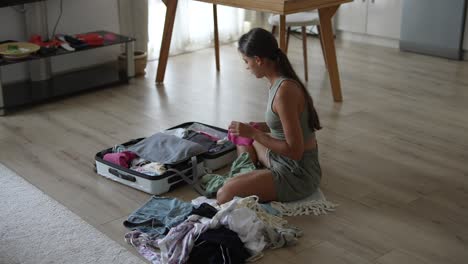 mujer empacando la maleta en casa
