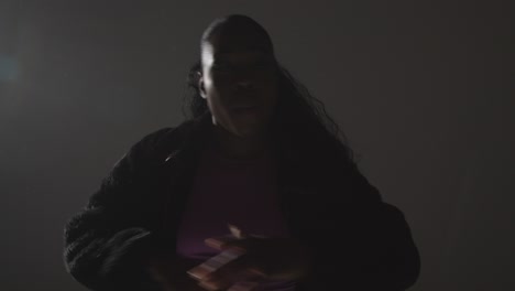 retrato de estudio de una mujer joven bailando con iluminación baja contra un fondo gris 8