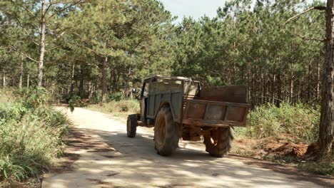 panning motion follow old rusty truck on rural pathway, persimmon plantation farm, vietnam