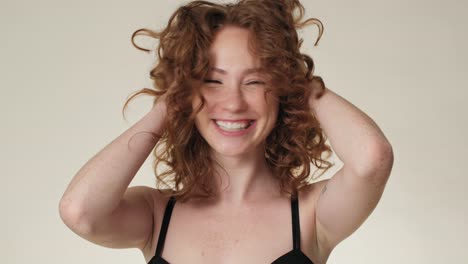 Portrait-of-cheerful-caucasian-red-head-woman-in-underwear-in-the-studio.