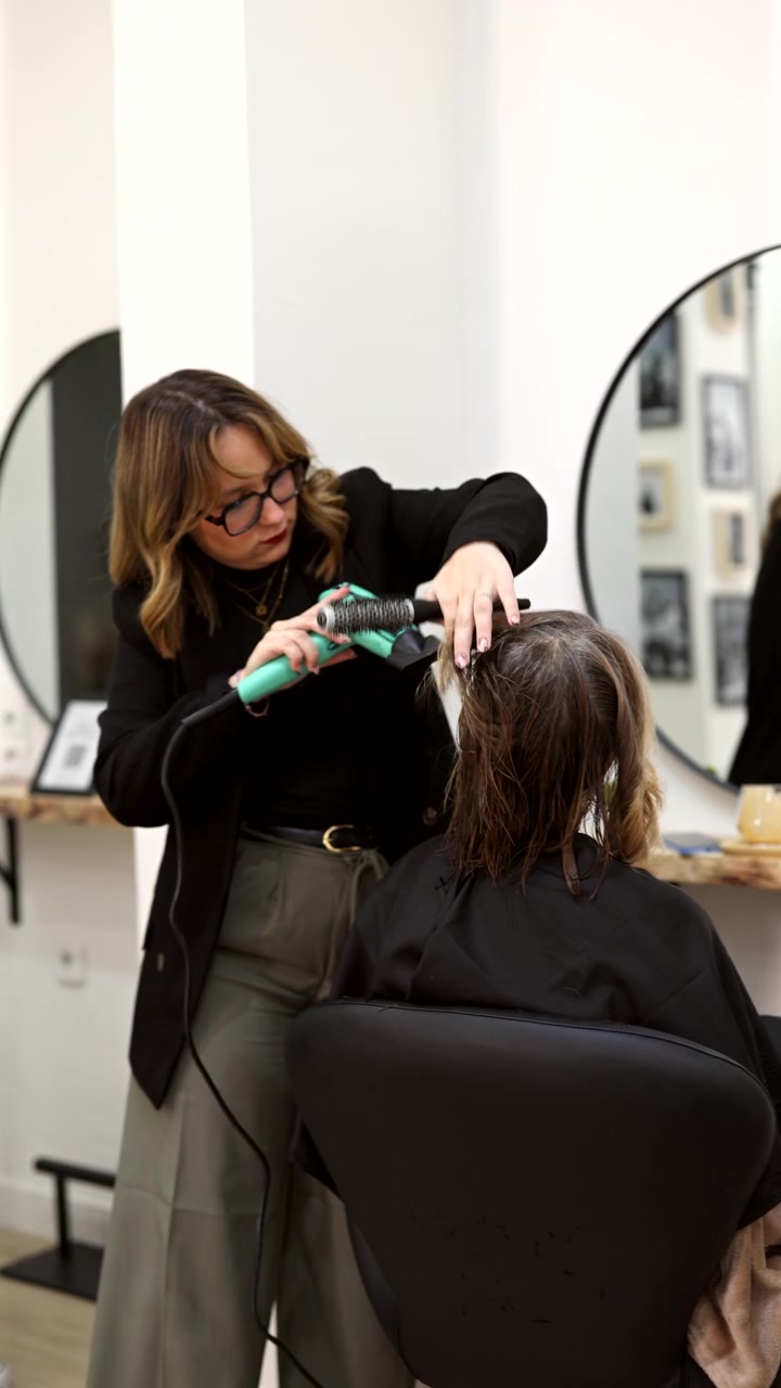 Professional Hairdresser Drying Client's Hair in Modern Salon