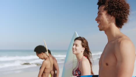 Group-of-friends-standing-with-surfboard-4k