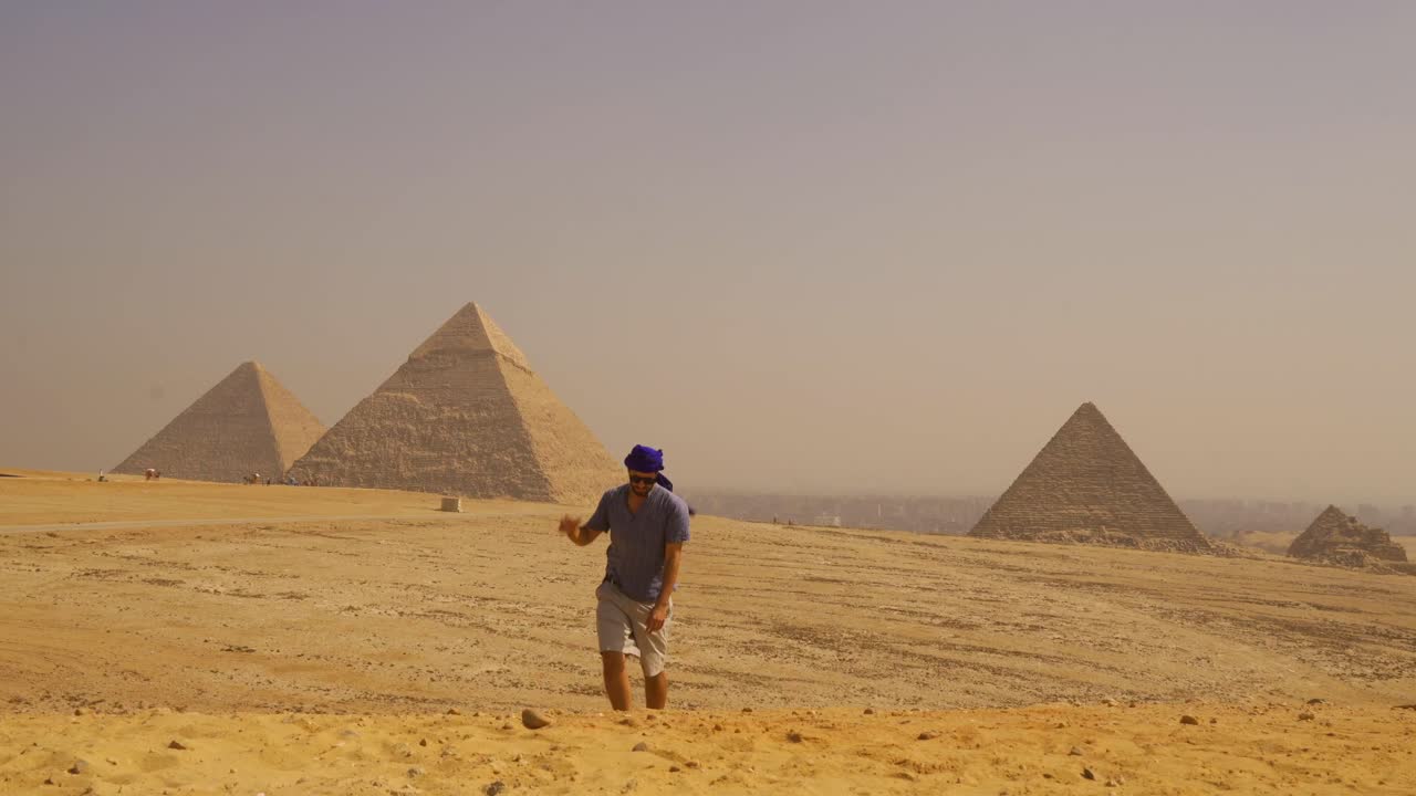 Uomo che cammina nel deserto egiziano con le piramidi