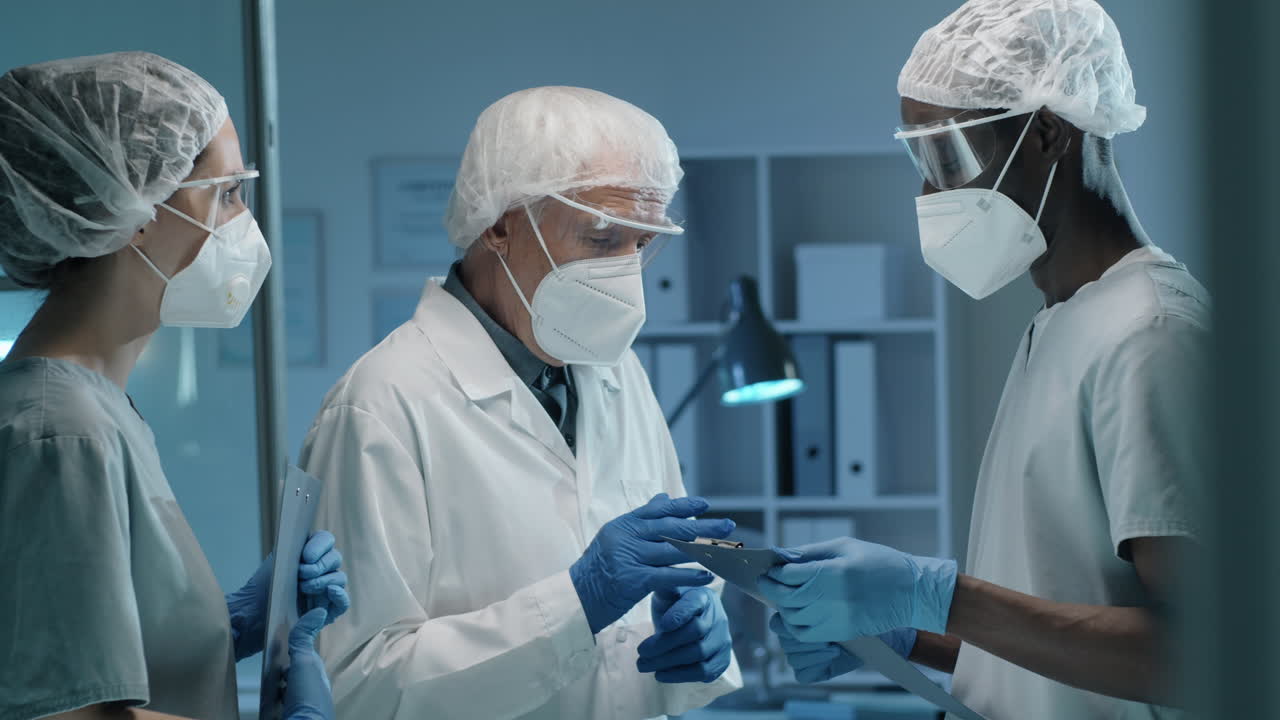 Premium stock video - Senior lab scientist in mask speaking with young ...