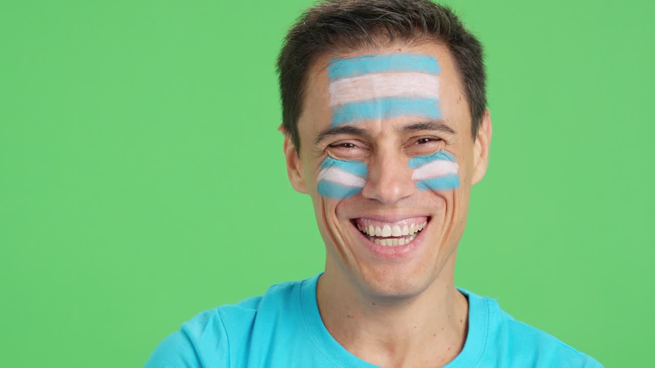 Man with a argentine flag painted on the face smiling