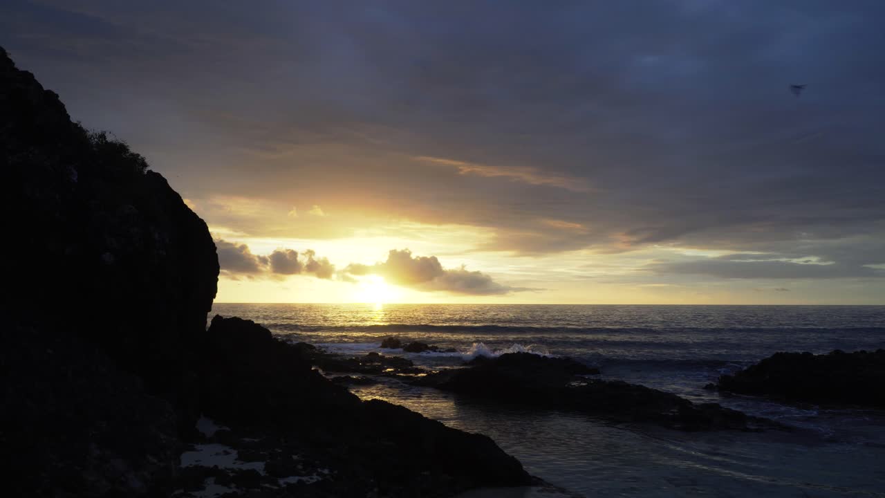 The bright sunset in the horizon over the waters of Fiji islands - wide shot