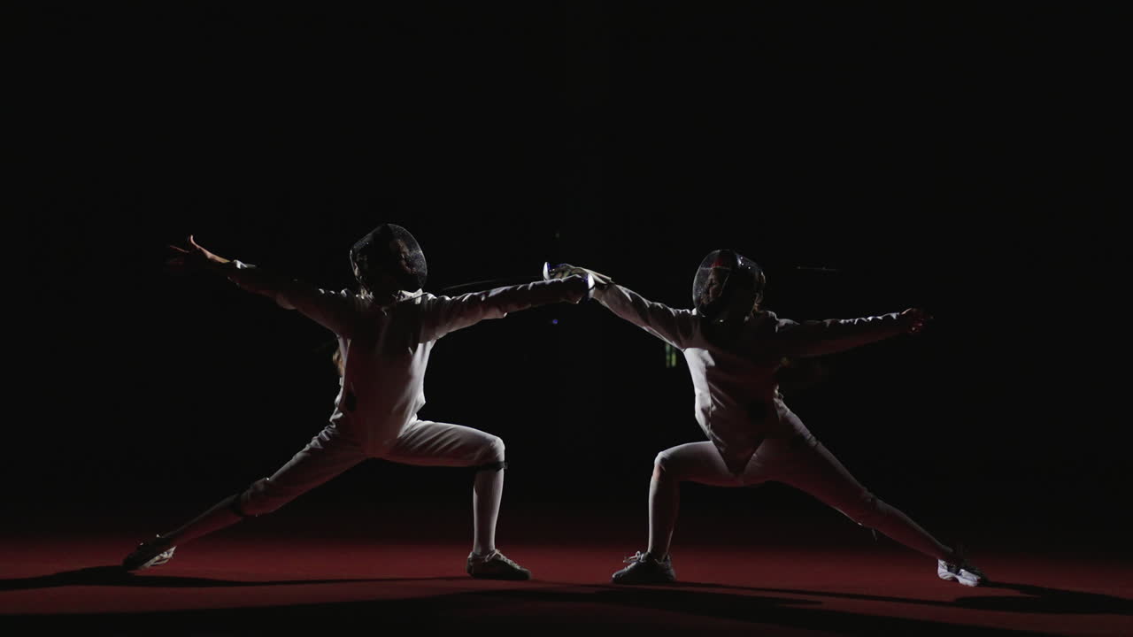 두 명의 여성 펜싱 선수 들 이 대회 에서 활동 하고 있다