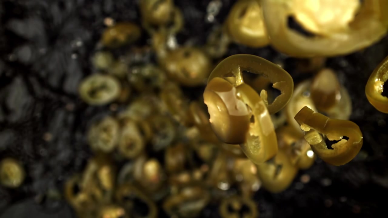 Jalapeños a fette sottaceto che cadono al rallentatore estremo