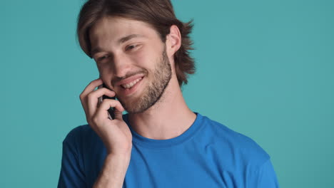 caucasian man in front of camera on blue background.