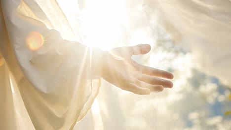 a hand reaching towards sunlight, captured in a soft-focus, low-angle shot