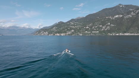 4K-Aerial---Following-medium-shot-behind-a-classic-boat-in-Lake-Como,-Italy