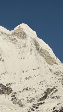 vertical snowcapped mountains in nepal and clear blue sky, vertical video for social media instagram reels and tiktok of snowy winter himalayas mountains covered in snow in nepal