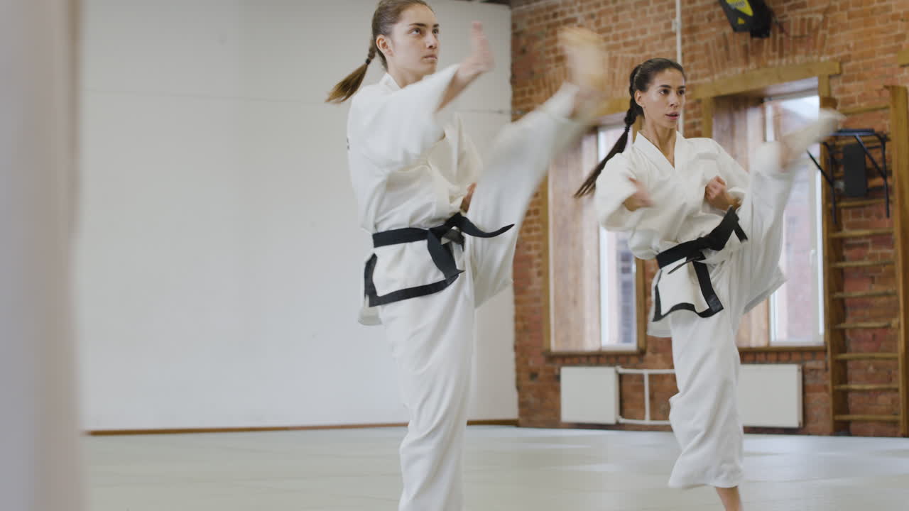 Two girls practising kicks and punches