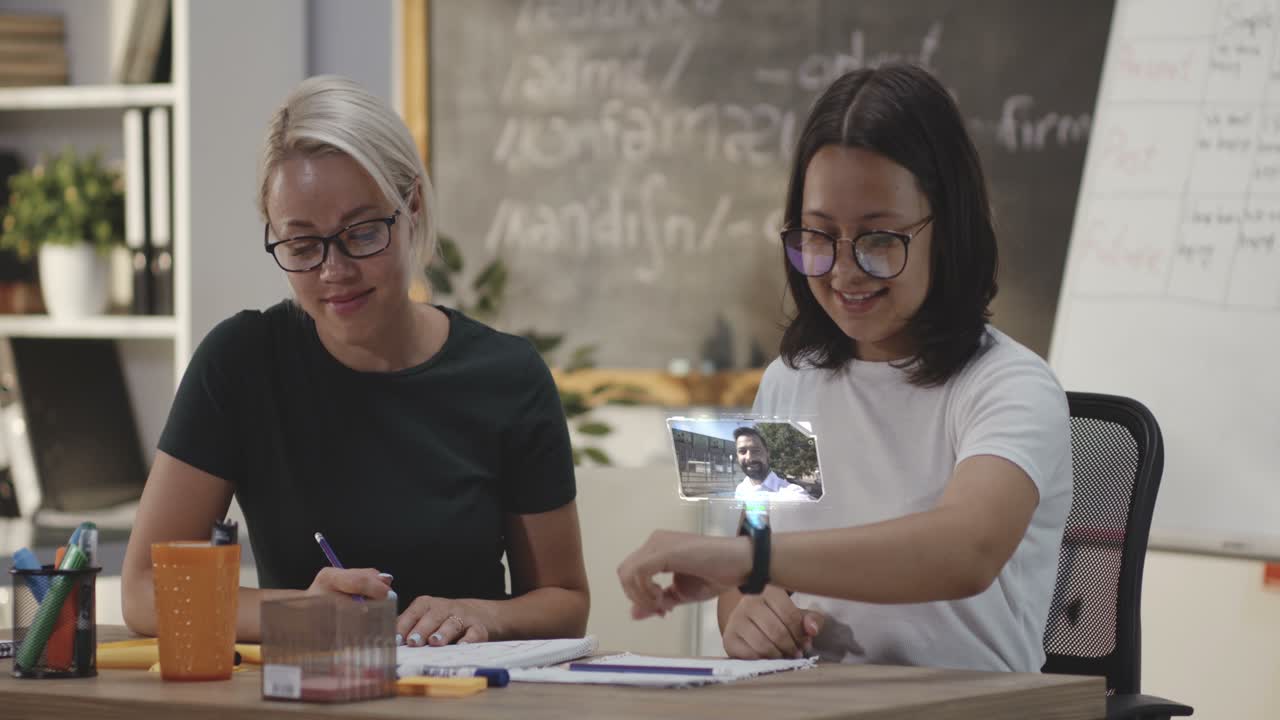 Student Using a Smartwatch for a Video Call. Medium shot of a male student using a smartwatch for a video call with his father while having a tutoring course
