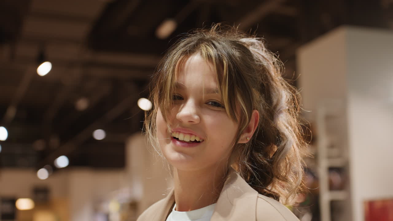 Niña riendo entre productos de una tienda; niña alegre interactúa con peluches durante una visita de compras; niña pequeña juega con animales de peluche mientras compra con su familia en una tienda
