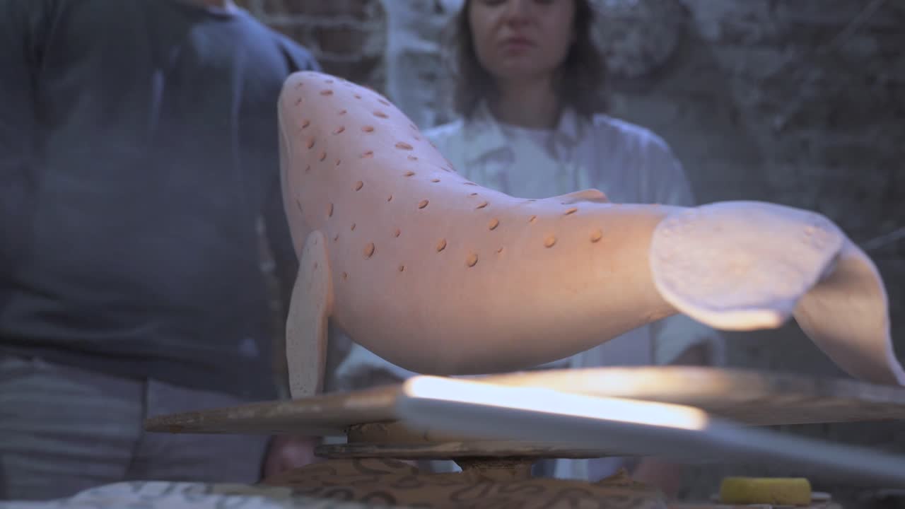 пара наблюдает за художественной скульптурой кита