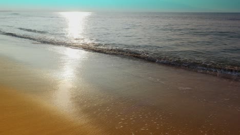 seamless loop, tropical beach sand, foot prints as people walk through waves