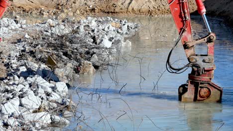 excavator demolishing a flooded structure