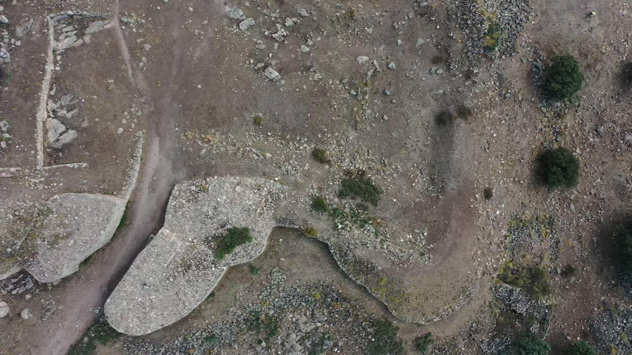 vuelo con vista aérea sobre la reconstrucción de las murallas y la entrada de una antigua ciudad celta de la edad del hierro vemos estructuras de vivienda unidas a la pared interior en ávila, españa