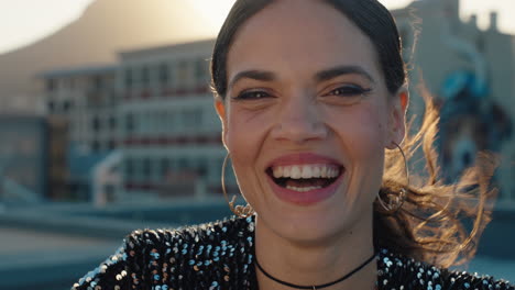 retrato de una mujer hermosa riendo en la ciudad pareciendo feliz con el viento soplando el cabello al atardecer concepto de autoimagen positiva femenina