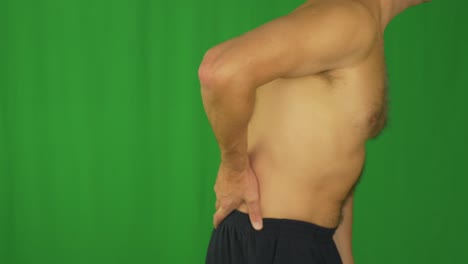 side view of caucasian man torso. man stroking lower back by hands.