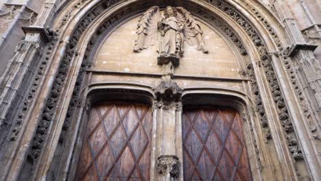 architectural detail of a gothic church entrance with angel statue