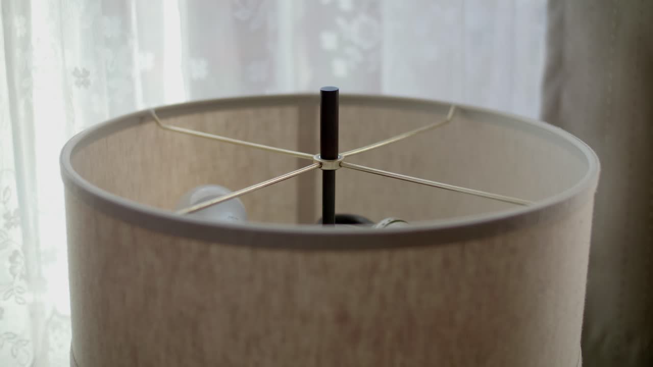 Steady closeup view of round cover surrounding floor lamp in home, highlighting its design.