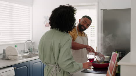 amor, vino y pareja en la cocina cocinando