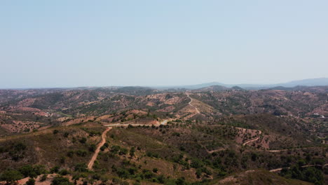 Vuelo-Aéreo-Sobre-El-Gigantesco-Paisaje-Montañoso-Durante-El-Día-Soleado-En-Portugal,-Algarve