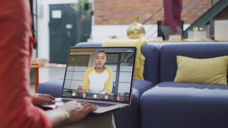 Biracial-businesswoman-using-laptop-for-video-call-with-african-american-business-colleague